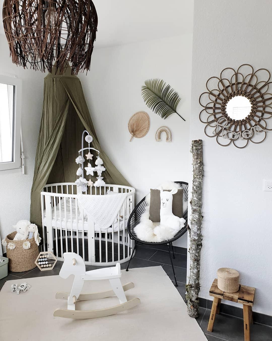 pokój dla dziecka z białym łóżeczkiem i baldachimem w kolorze oliwkowym