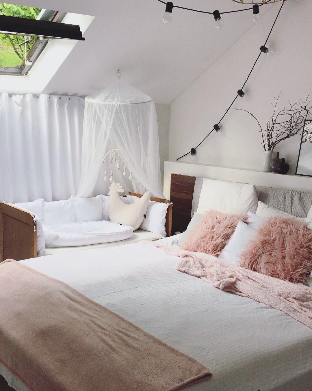 mała sypialnia na poddaszu z różowymi akcentami i kącikiem dla niemowlaka z baldachimem