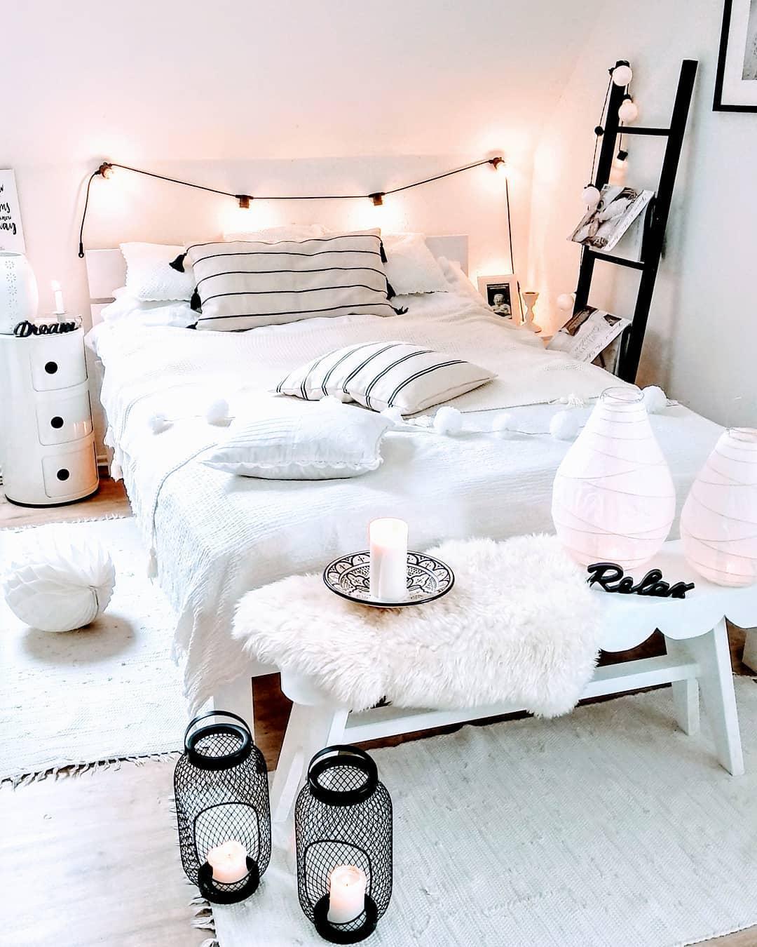 jasna sypialnia ozdobiona girlaną świetlną