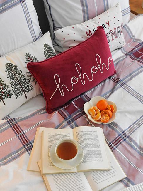 świąteczna pościel w czerwoną kratę na łóżku z świątecznymi poduszkami i otwartą ksążką