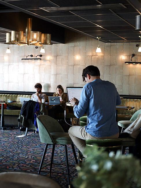 Pracujący mężczyzna w przestrzeni coworking z innymi ludźmi