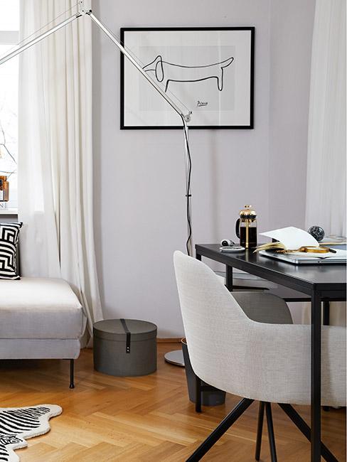 małe biurko pod oknem w salonie z popielatą ścianą
