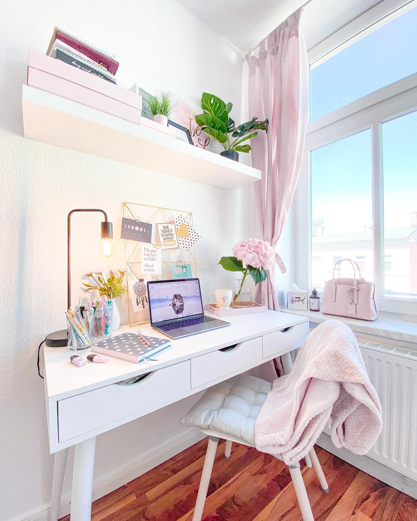 białe biurko pod oknem w pokoju dziecięcym z różowymi tekstyliami