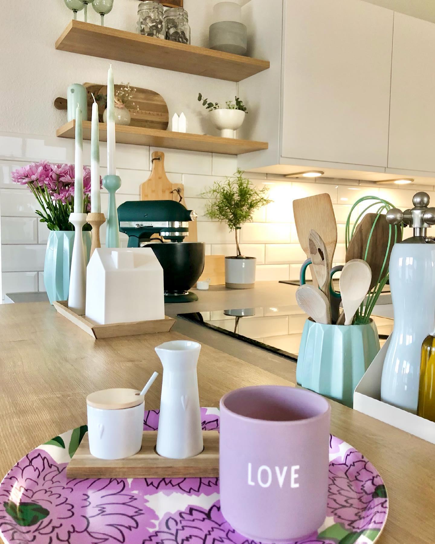 Pastelowa kuchnia z dekoracjami w kolorze miętowym i fioletowym kubkiem
