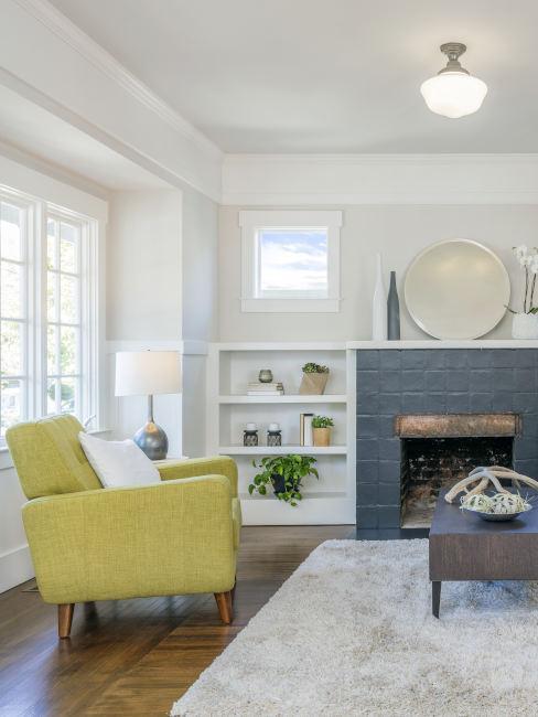 Wystrój salonu z jasnym zielonym fotelem i dużym kominkiem