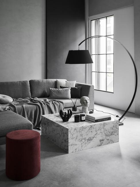Salon w odcieniach szarości z marmurowym stolikiem i lampą łukową
