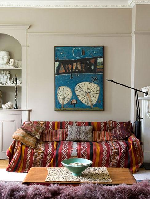 Salon w stylu boho z narzutą na kanapę w kolorze terakoty z marokańskim wzorem