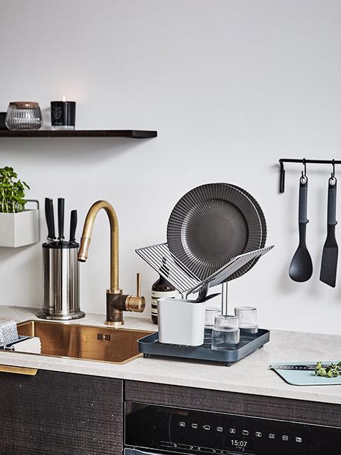 szare talerze w nowoczesnej kuchni ze złotym kranem