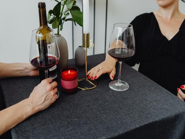 Widok chłopaka i dziewczyny przy stole pijących wino