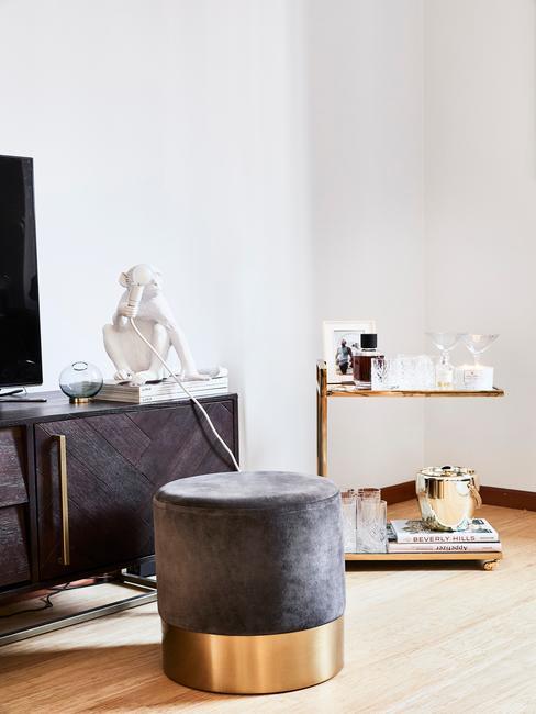 Salon glamour z ciemnoszarą sofą, brązową komodą i złotymi akcentami