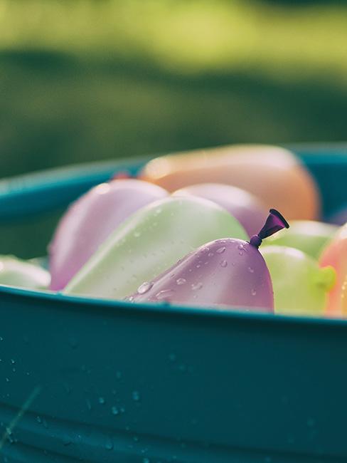 kolorowe balony na wodę w wiaderku w ogrodzie