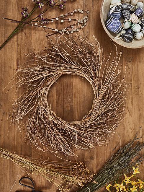 materiały do wieńca wielkanocnego: gałązki, pisanki i forsycja