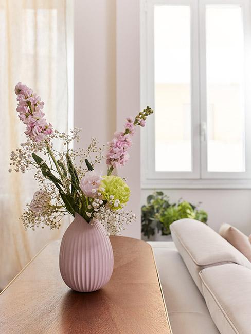 piękny bukiet wiosennych kwiatów w różowym wazonie w jasnym pastelowym salonie