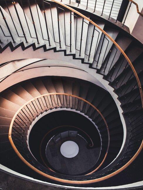 klatka schodowa z krętymi schodami z ciemnego drewna