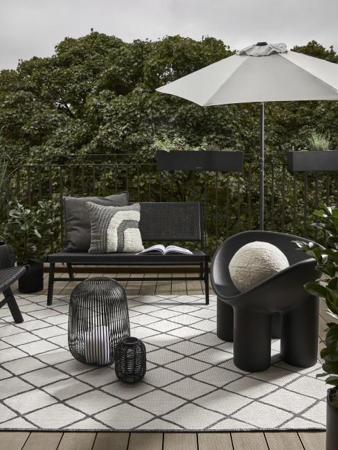 nowoczesny przedogródek z czarnymi meblami i szarym parasolem