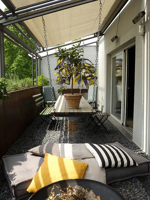 dom z werandą szarymi i żółtymi tekstyliami