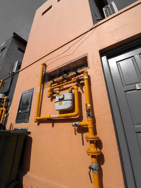 pomarańczowe rury na pomarańczowej ścianie przed wejściem do budynku