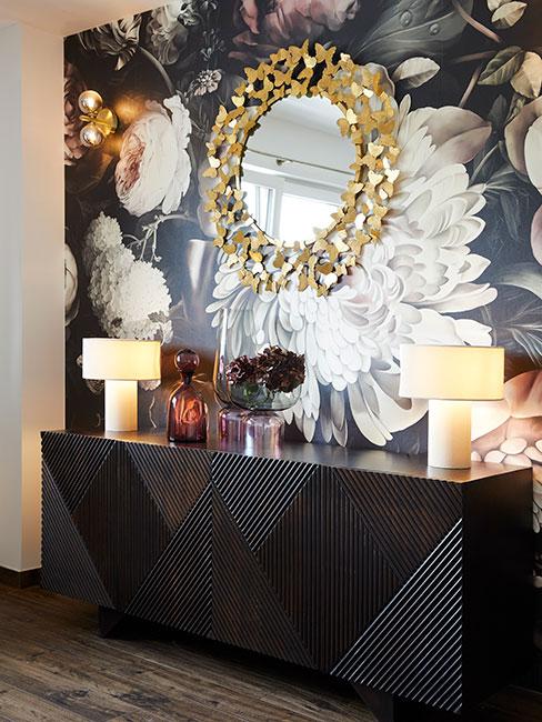 lustro typu słoćce na ścioanie z fototapetą i ciemną komodą w stylu glamour