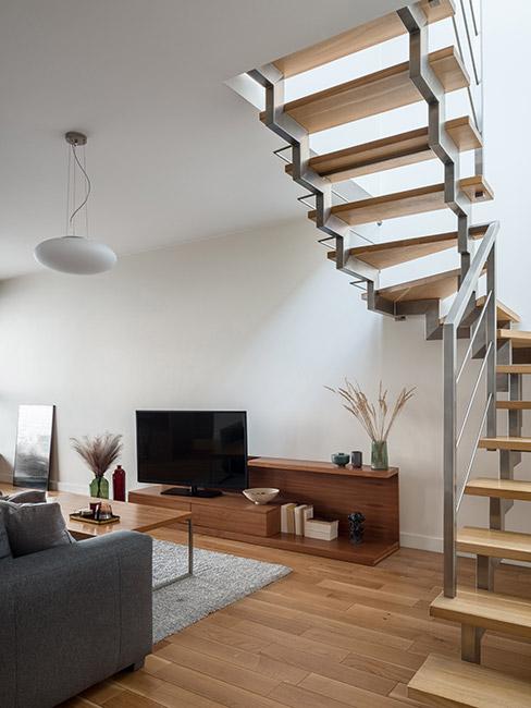 drewniane Schody w salonie nowoczesnym z ciemnoszarą sofą