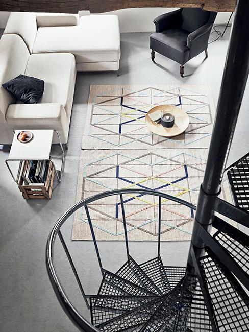 nowoczesny salon w lofcie ze spiralnymi schodami metalowymi i beżową sofą