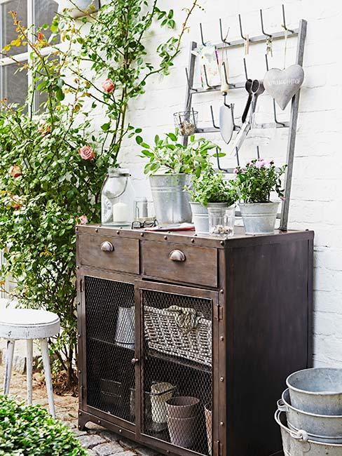 ogrodowa komoda, a na niej i obok kwiaty