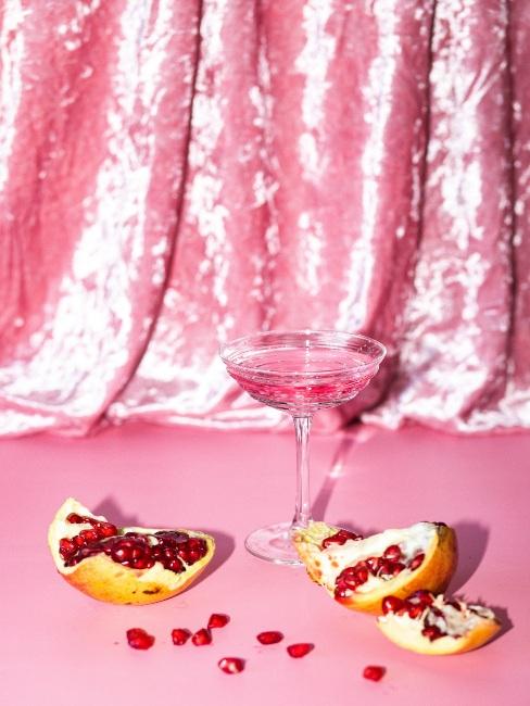 różowy drink na różowym tle, a obok granat
