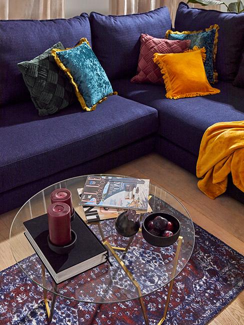 Fioletowa sofa w kolorze indygo z pomarańczowymi poduszkami w stylu retro