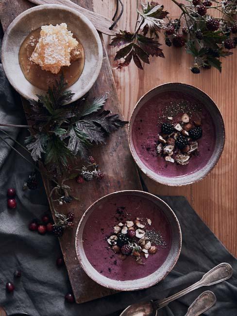 dwie miski z owsianką z jagodami acai