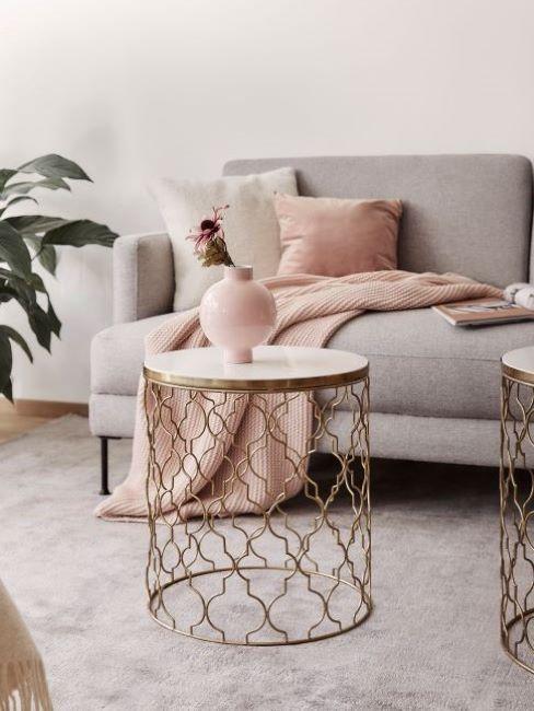 Salon z z popielatą sofą i tekstyliami w kolorze millennial pink
