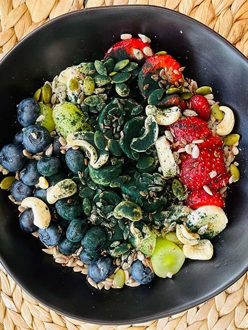 poke bowl z owocami posypanymi sproszkowanymi algami