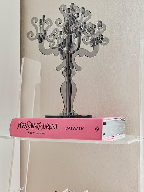 czarny plastikowy świecznik stojący na różowej książce