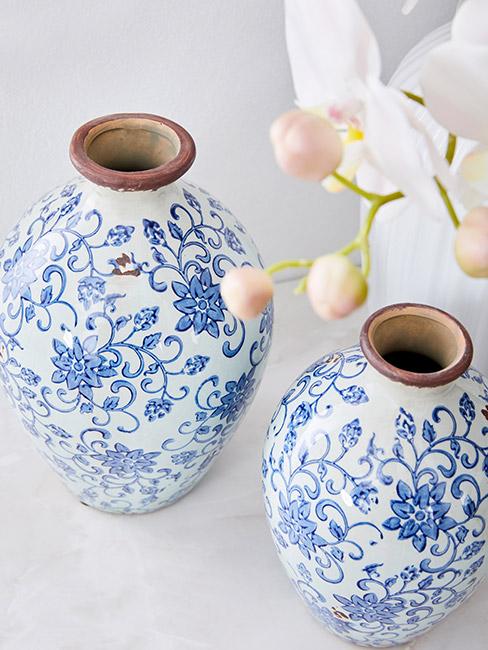 dwie porcelanowe wazy, a obok orchidea