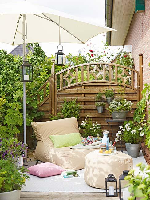 Pergola w ogrodzie oddzielająca taras z poduszkami of sąsiadów