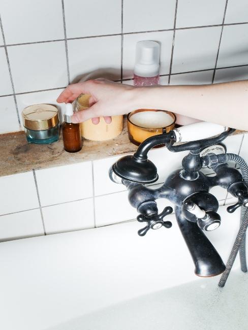 kobieta sięgająca po serum stojące obok wanny
