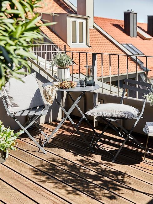 balkon w bloku z niewielkim meblami ogrodowymi