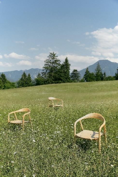 Drewniane krzesła stojące na alpejskiej łące z widokiem na góry
