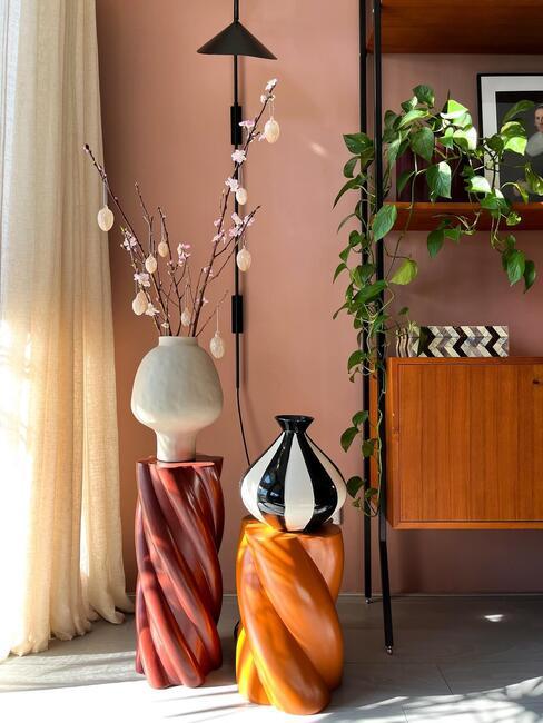 Wazon z kwitnącami gałązkami na stoliku pomocnicznym