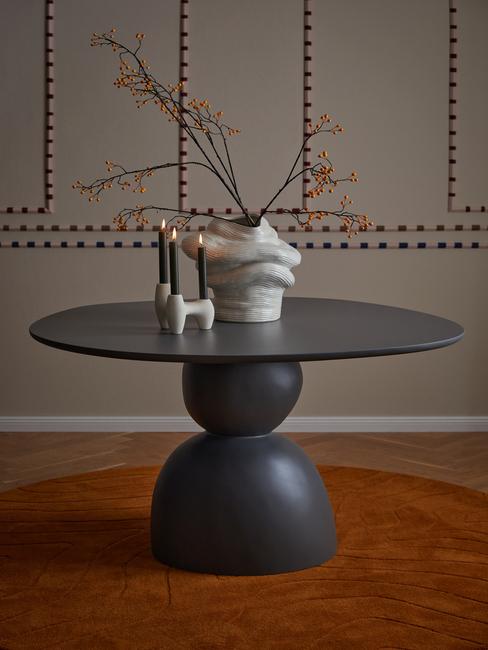 Wazon w organicznym kształcie na stole z kompozycją z gałęzi