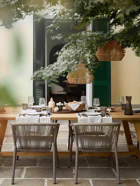 Drewniany stól nakryty do obiadu na tarasie