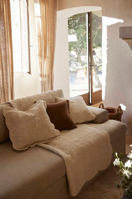 Rustykalne poduszki i koc na sofie