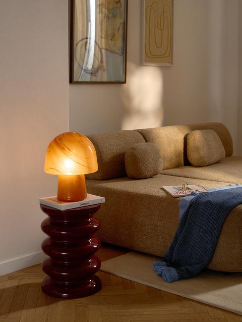 Lampa w kolorze ochry na stoliku pomocnicznym