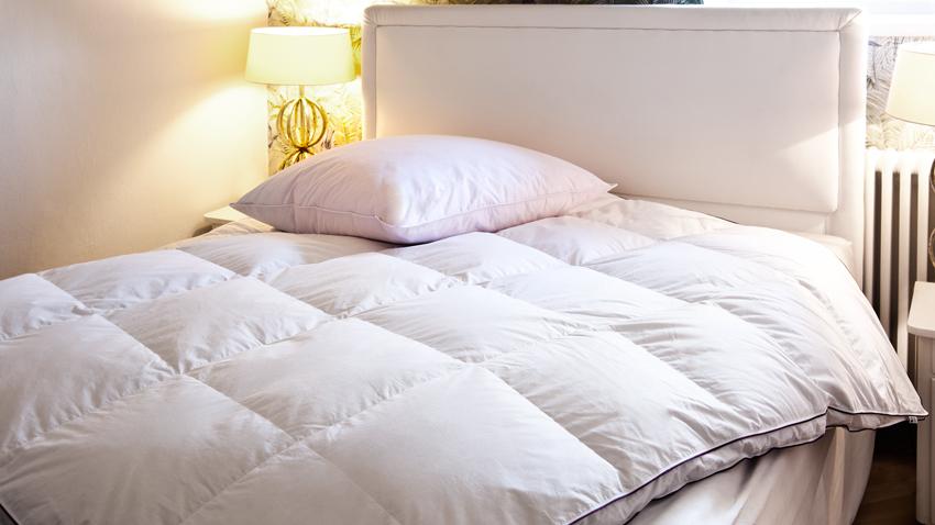 Matratzenschutz mit Bettware in Weiß auf Bett