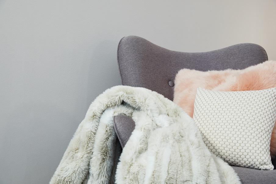 plaid gris clair en fourrure sur accoudoir de fauteuil gris