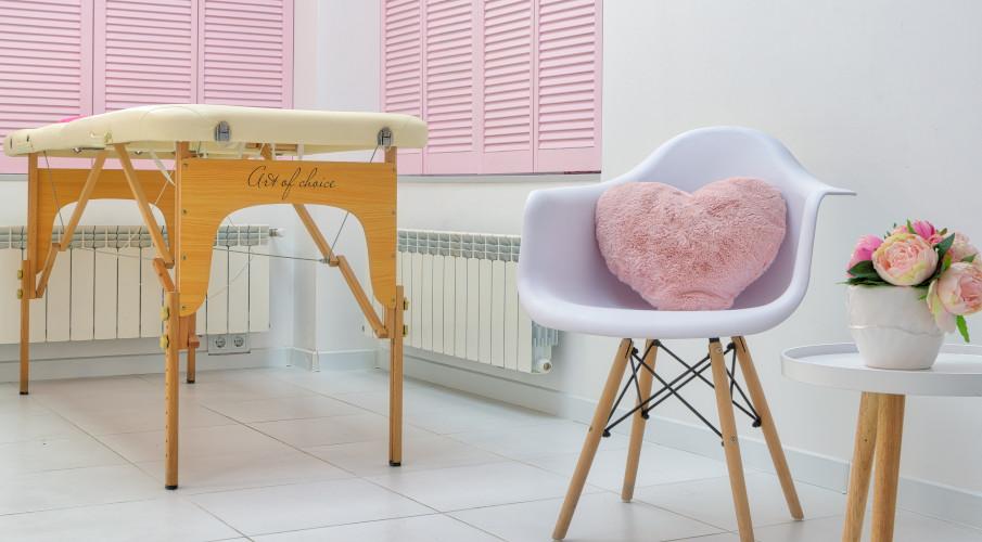 coussin coeur rose sur une chaise blanche