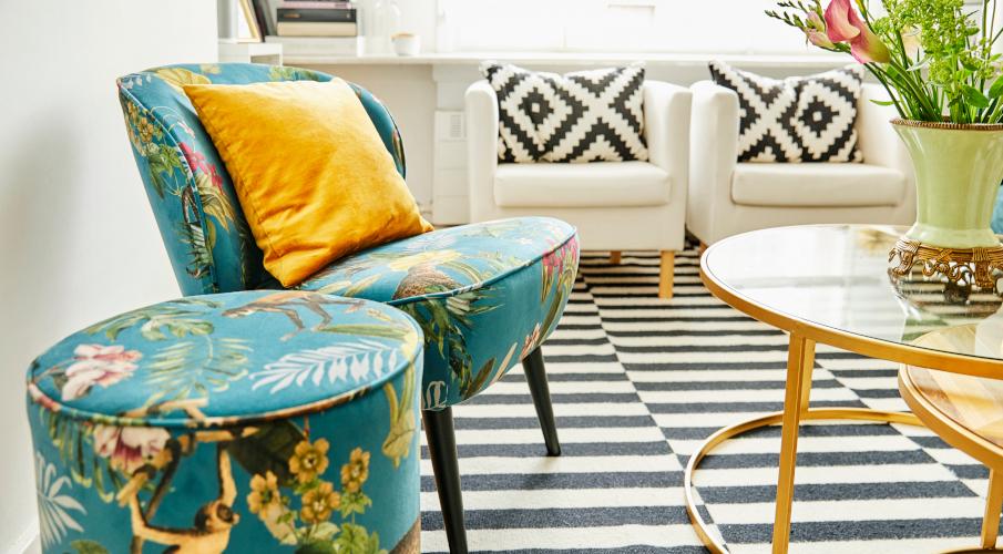 Fauteuil turquoise, coussin gris, commode en bois