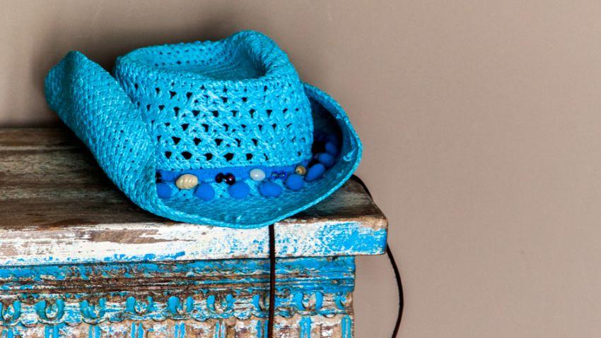 Pole to Pole blauwe cowboy hoed op een oude blauwe tafel