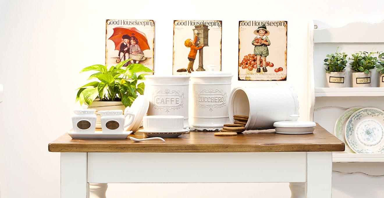 een witte houten tafel met een plant, witte potten en decoratie er op