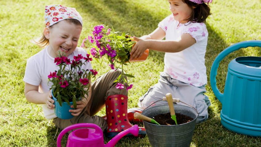bladhark kind tuin paarse bloemen roze gieter