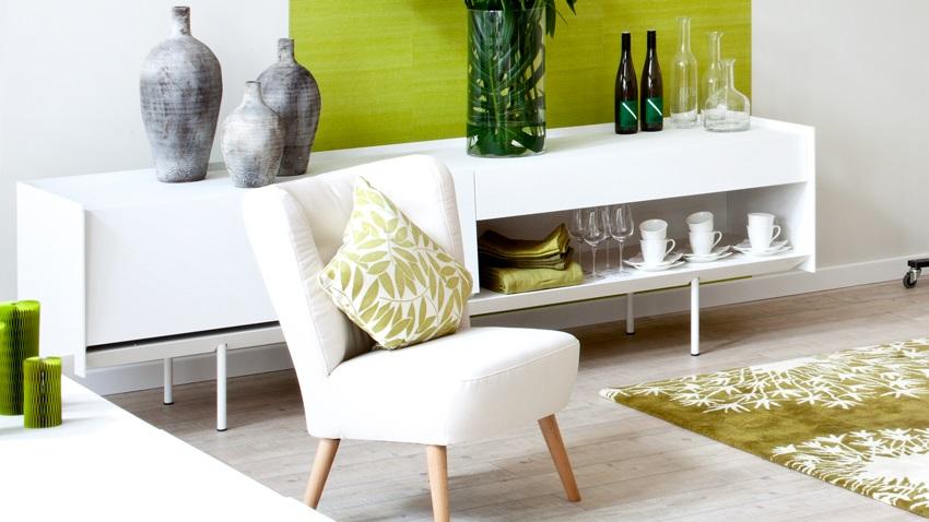 modern laag dressoir tegen groene muur