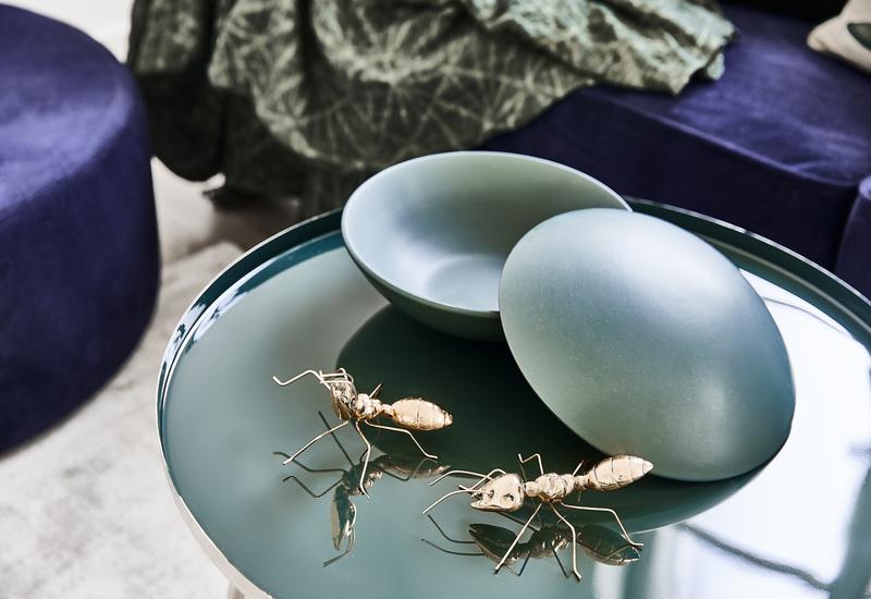 Groene hoogglans salontafel met gouden decoratieve mieren er bovenop